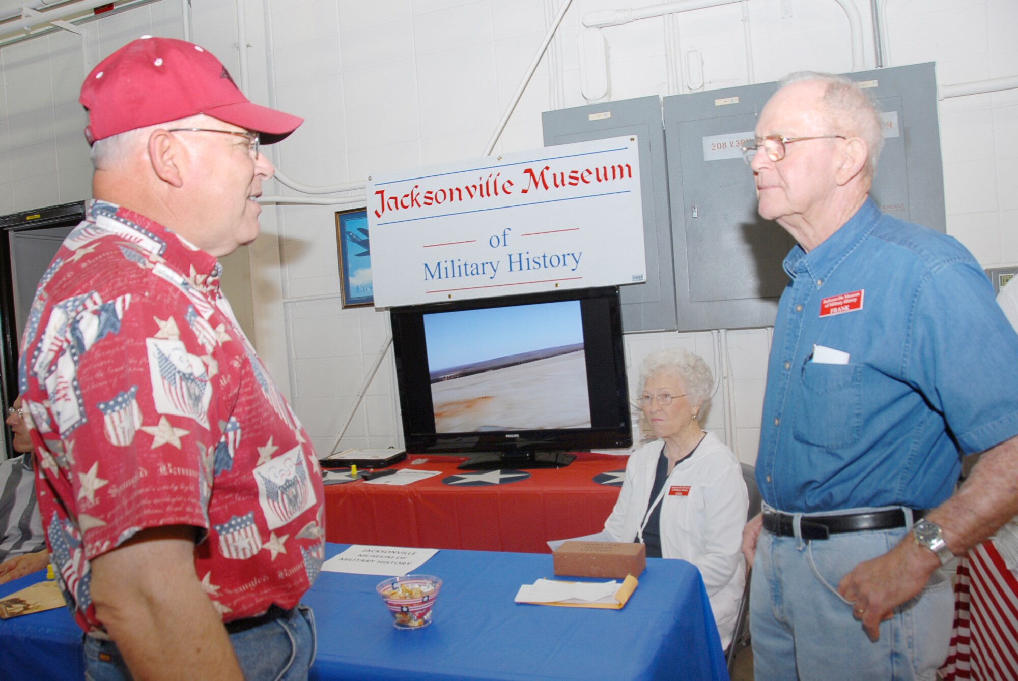 James Jackson, 189th Airlift Wing retiree (left), and Frank McClure, of the Jacksonville Military Museum (right), talk about military history in the local area. Mrs. McClure is seated at the table. (U.S. Air Force photo by Master Sgt. Dianna Seerey)