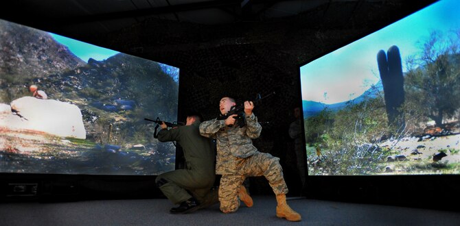 JOINT BASE MCGUIRE-DIX-LAKEHURST, N.J. – Capt. Kevin Snow, 818th Global Mobility Squadron Assistant Operations Officer, and Capt. Frank Rovello, Readiness Flight Commander, exchange gunfire with insurgents during a battlefield training scenario in the 621st Contingency Response Wing’s new virtual firearms training simulator here April 15. The five wraparound high-resolution screens can display many realistic combat environments the CRW Airmen may encounter in its worldwide mission to provide no-notice expeditionary airlift support. (U.S. Air Force photo/Tech. Sgt Parker Gyokeres)