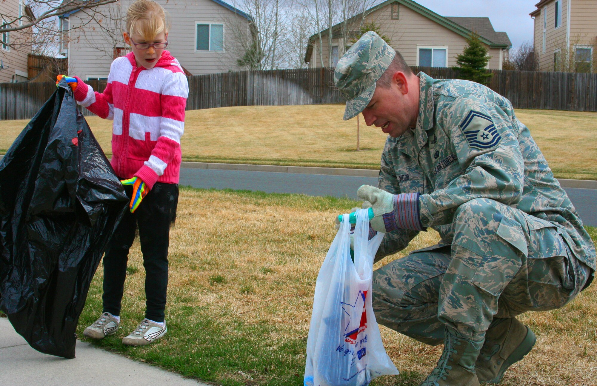 Gillian Barney (left) and Senior Master Sgt. John Moor, the superintendent of plans and programs for the 310th Space Wing, picks up garbage at Remington Park on April 16. The 310th Space Wing adopted the park in April and will care for the grounds through 2010.