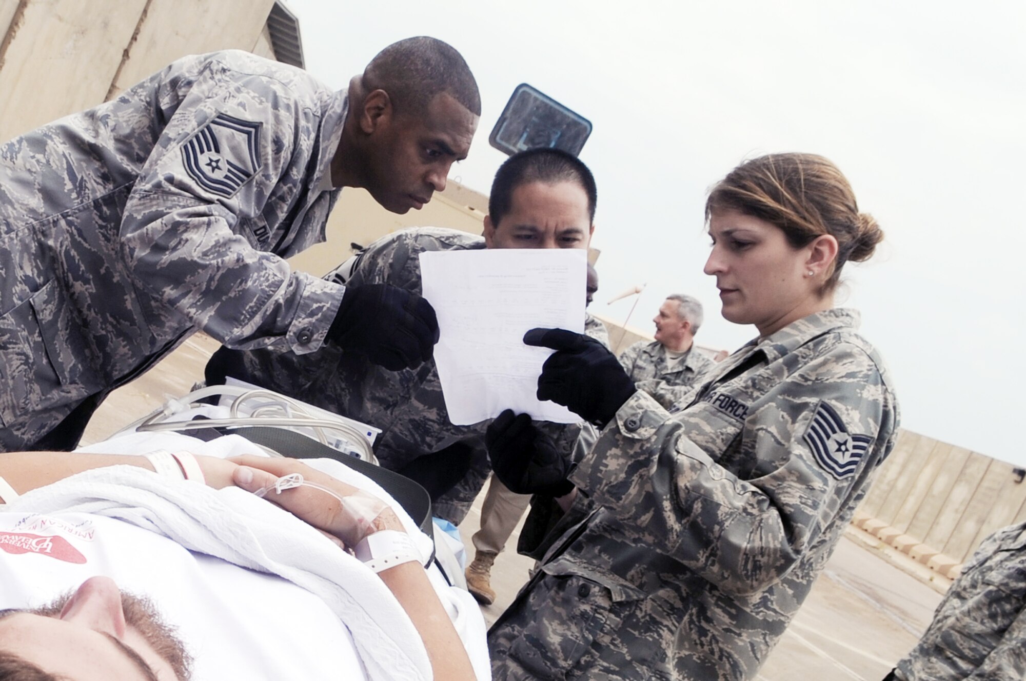 332nd Expeditionary Medical Group members look over a patient's information before taking him inside the Air Force Theater Hospital during an aeromedical evacuation mission April 17, 2010, at Joint Base Balad, Iraq. (U.S. Air Force photo/Senior Airman Brittany Y. Bateman)