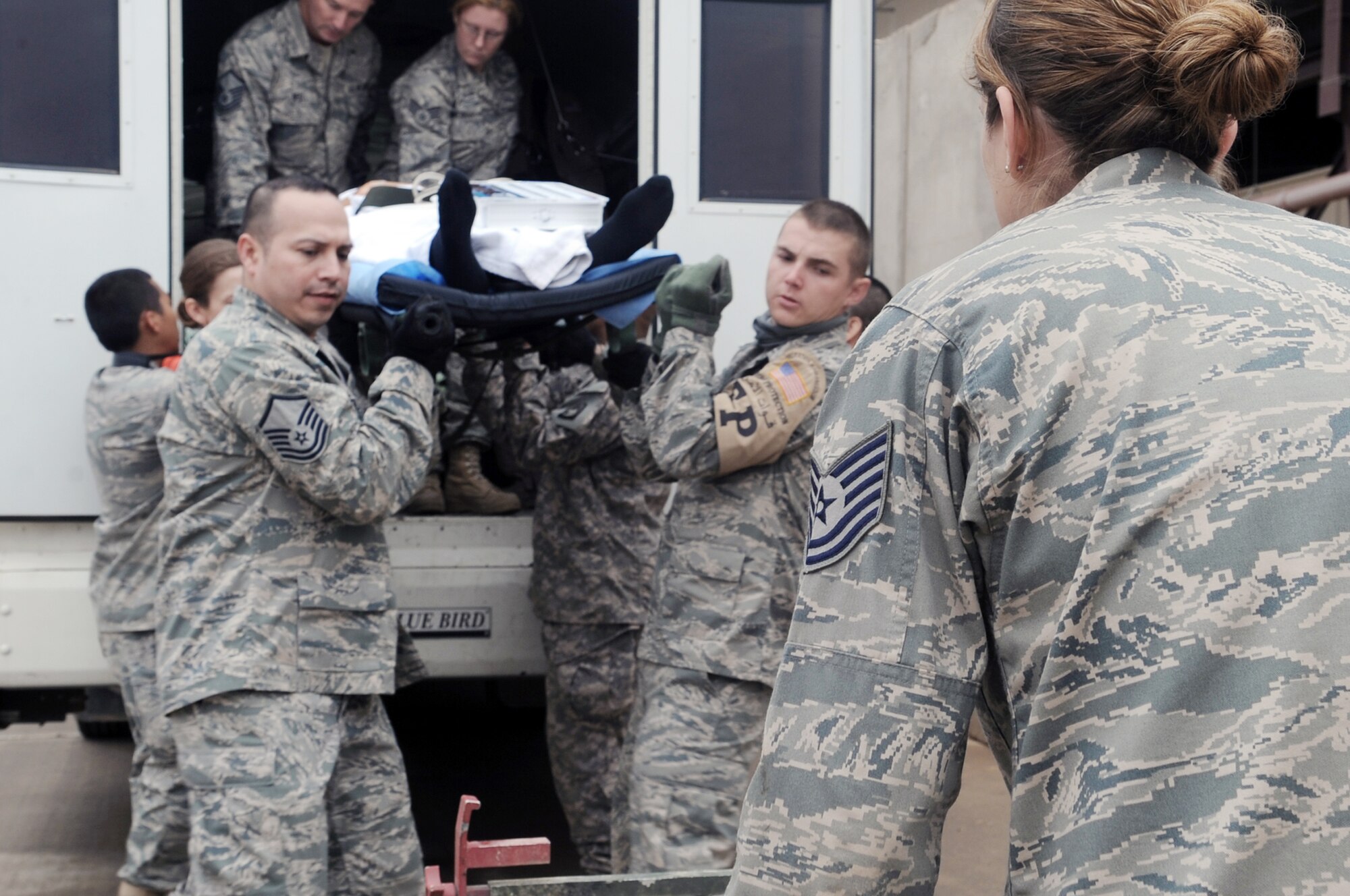 332nd Expeditionary Medical Group members unload a patient from a bus to be transferred to the Air Force Theater Hospital during an aeromedical evacuation mission April 17, 2010, at Joint Base Balad, Iraq. The 332nd EMDG is expecting the average patient load to increase by about 50 patients per day. (U.S. Air Force photo/Senior Airman Brittany Y. Bateman)