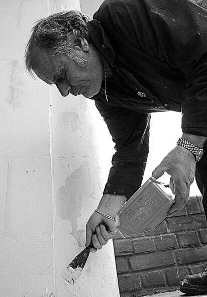 RAF MILDENHALL, England – Ivan Howard, 100th Civil Engineer Squadron, fills gaps in the surface of an entryway to prepare it for repainting April 19.  Repainting is one of several spring cleaning projects scheduled for Earth Week.  (U.S. Air Force photo/Staff Sgt. Christopher L. Ingersoll)