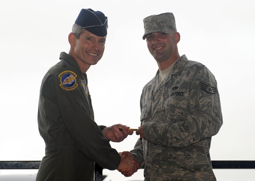 DYESS AIR FORCE BASE, Texas—Air Force Chief of Staff Gen. Norton Schwartz gives a ceremonial key to 317th Aircraft Maintenance Squadron crew chief Staff Sgt. Ryan Flores during a ceremony here April 16. Sergeant Flores, the 2009 Air Mobility Command Crew Chief of the Year, represented the maintenance arm of the airlift mission.  The 317th Aircraft Maintenance Squadron will be responsible for the safety and maintenance of theaircraft.  (U.S. Air Force photo/ Senior Airman Felicia Juenke)