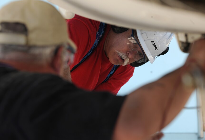 MOODY AIR FORCE BASE, Ga. -- Michael Douglass, National Museum of the United States Air Force exhibit specialist, checks the underbelly of an F-105 Thunderchief static aircraft for radioactive panels as Benton Wilmoth, 88th Civil Engineering Squadron radiation safety specialist, looks on here April 12. The NMAF is located at Wright-Patterson Air Force Base, Ohio. (U.S. Air Force photo by Airman 1st Class Benjamin Wiseman/RELEASED)
