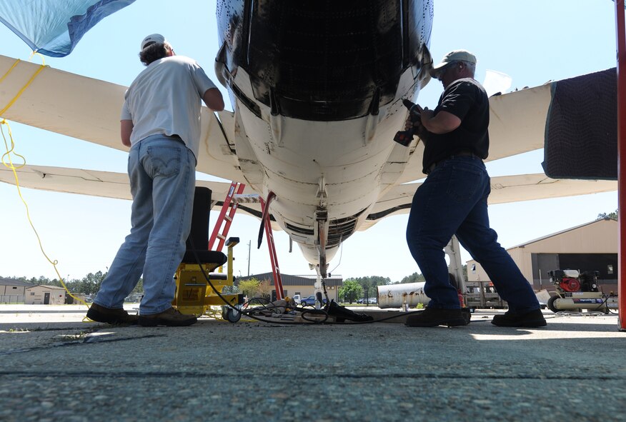 MOODY AIR FORCE BASE, Ga. -- Benton Wilmoth and Christopher Anthony, 88th Civil Engineer Squadron radiation safety office specialists, remove magnesium-thorium panels from an F-105 Thunderchief static aircraft here April 12. They helped remove the low-level radioactive panels to eliminate future hazards and replaced it with fiberglass. (U.S. Air Force photo by Airman 1st Class Benjamin Wiseman/RELEASED)