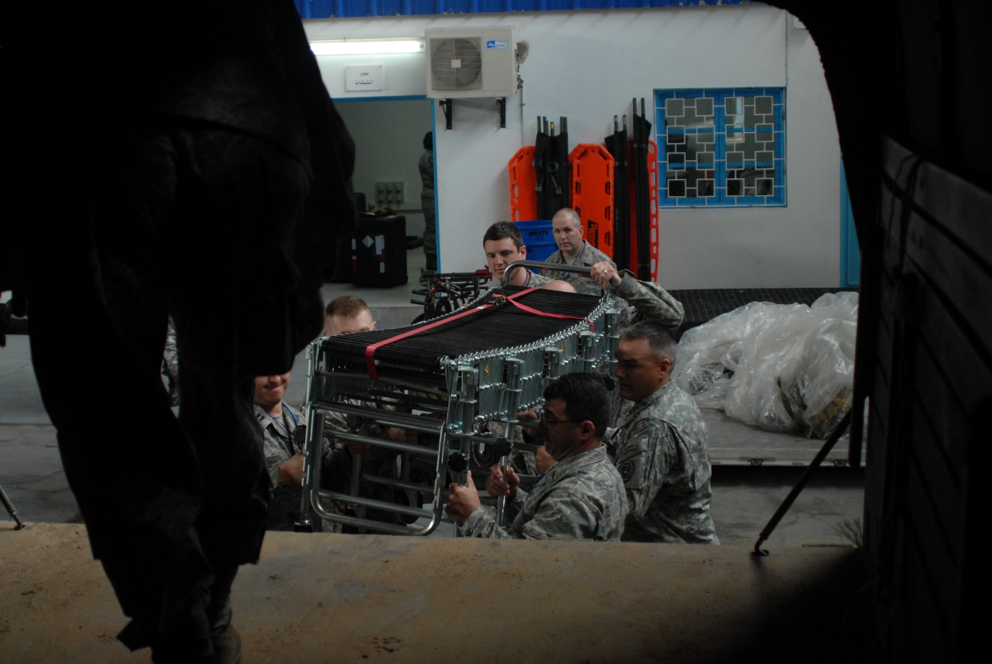 Several service members from Wyoming, Arizona, Nevada, and Illinois help load parts of a decontamination system onto the bed of a truck at Kharrouba Air Base, Tunisia during the MEDLITE-10 exercise. These American service members are in Tunisia as part of the U.S. partnership program with the North African nation, exchanging medical treatment practices and programs. (USAF Photo by Master Sgt. Paul Mann/Released)
  