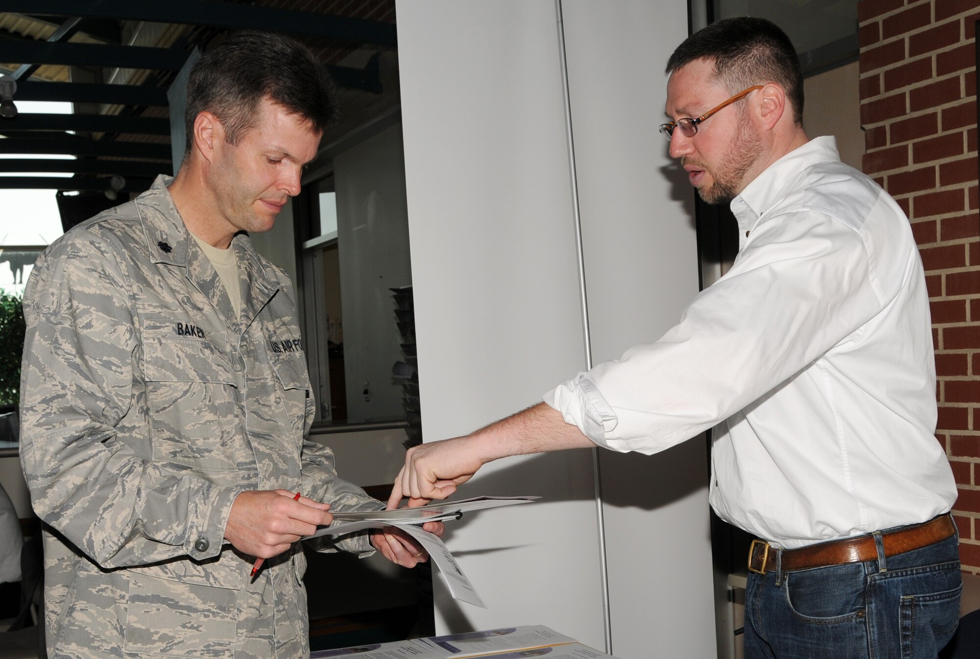 Lt. Col. Patrick Baker, a medical service officer with the 178th Fighter Wing, looks at information over education opportunites with Seth Gordon, Associate Director of Enrollment Services at Antioch University McGregor. The 178th FW Retention Office held a career fair April 9 and 10. 