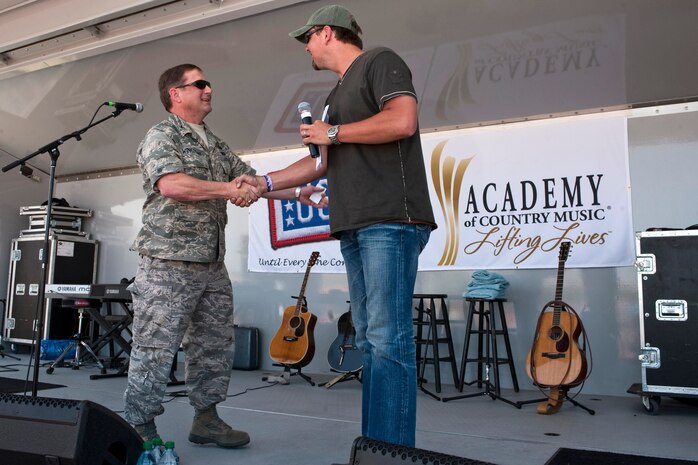 NELLIS AIR FORCE BASE, Nev. --  Col. Steven Winklmann, 99th Air Base Wing, vice commander shakes the hand of Storme Warren host of the television show "Headline Country" during the Academy of Country Music's USO concert at Nellis Air Force Base April 17, 2010. (U.S. Air Force photo by Tech. Sgt. Michael R. Holzworth)
