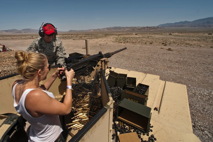 NEVADA TEST AND TRAINING RANGE --  Staff Sgt. Joshua Svendsen, a combat arms instructor assigned to the 99th Ground Combat Training Squadron assists country music singer LeAnn Rimes to fire 50 caliber machine gun from atop a HUMVEE at the 99th GCTS firing range April 17, 2010. The Academy of Country Music and the USO  toured  the 99th GCTS before performing a free concert at Nellis Air Force Base.  (U.S. Air Force photo by Tech. Sgt. Michael R. Holzworth)


