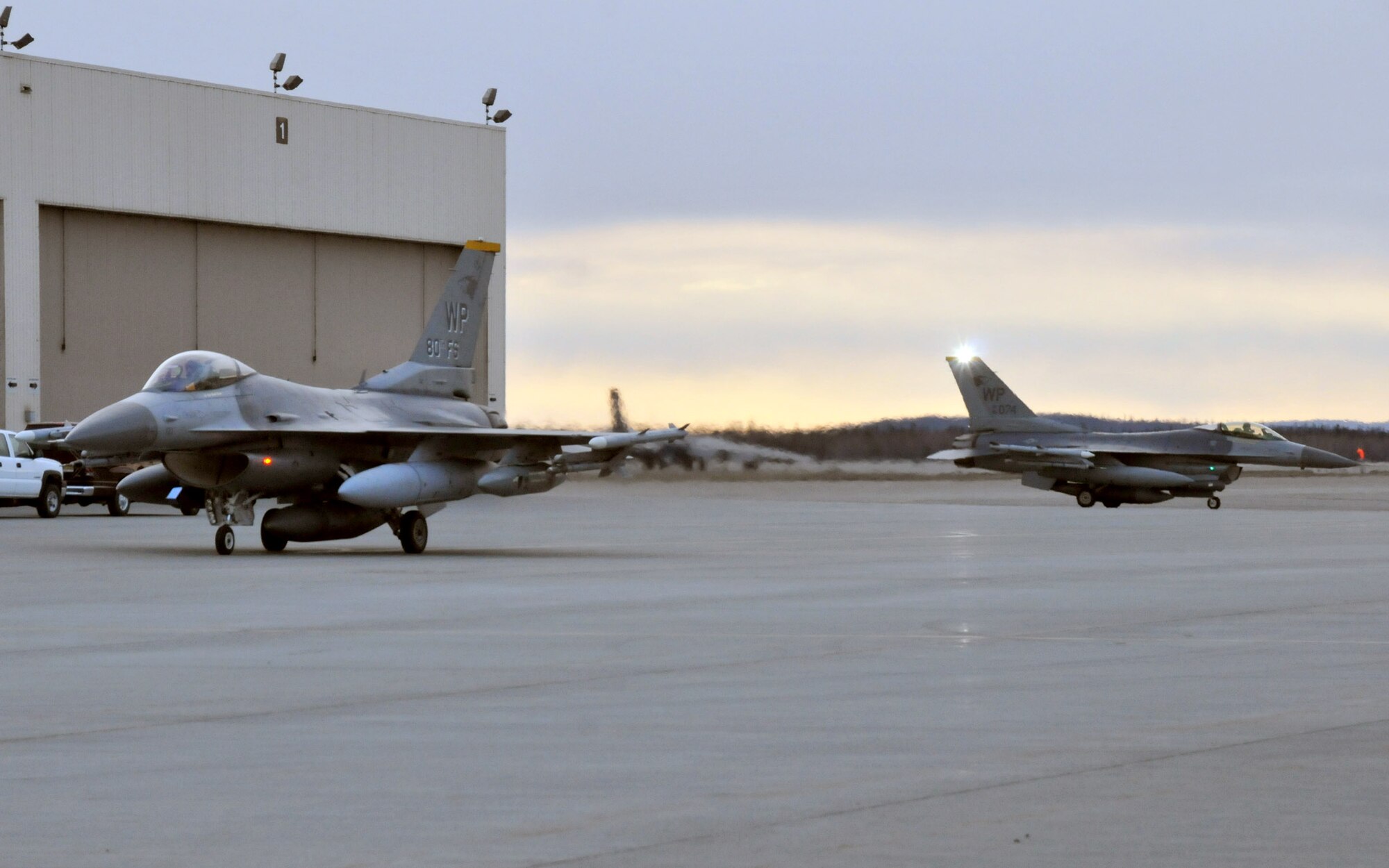F-16 Fighting Falcons pilots with the 80th Fighter Squadron taxi in at Eielson Air Force Base, Alaska, after flying from Kunsan Air Base, Alaska, Republic of Korea. Approximately 185 Airmen from Kunsan deployed to Eielson to participate in Red Flag-Alaska, a 10-day air combat training exercise that provides multi-service, multi-platform coordinated, combat operations in a simulated combat environment. (U.S. Air Force photo/Capt. Shannon Collins)