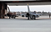 A crewchief with the 8th Aircraft Maintenance Squadron's 80th Aircraft Maintenance Unit marshals in the last of the F-16 Fighting Falcons to arrive to Eielson Air Force Base, Alaska, from Kunsan Air Base, Republic of Korea. Approximately 185 Airmen from Kunsan deployed to Eielson to participate in Red Flag-Alaska, a 10-day combat training exercise that provides multi-service, multi-platform coordinated, combat operations in a simulated combat environment. (U.S. Air Force photo/Capt. Shannon Collins)