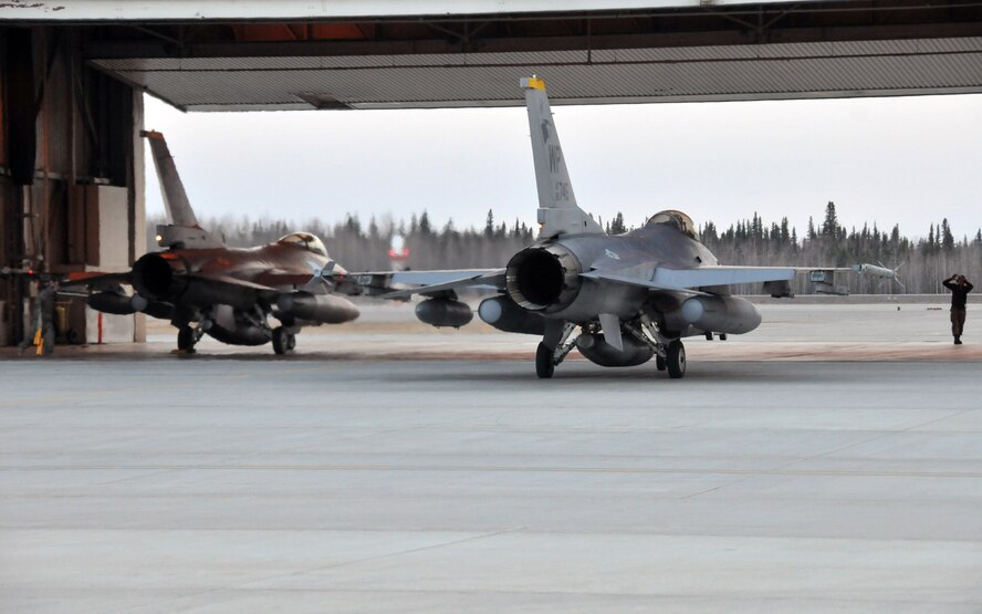 A crewchief with the 8th Aircraft Maintenance Squadron's 80th Aircraft Maintenance Unit marshals in the last of the F-16 Fighting Falcons to arrive to Eielson Air Force Base, Alaska, from Kunsan Air Base, Republic of Korea. Approximately 185 Airmen from Kunsan deployed to Eielson to participate in Red Flag-Alaska, a 10-day combat training exercise that provides multi-service, multi-platform coordinated, combat operations in a simulated combat environment. (U.S. Air Force photo/Capt. Shannon Collins)