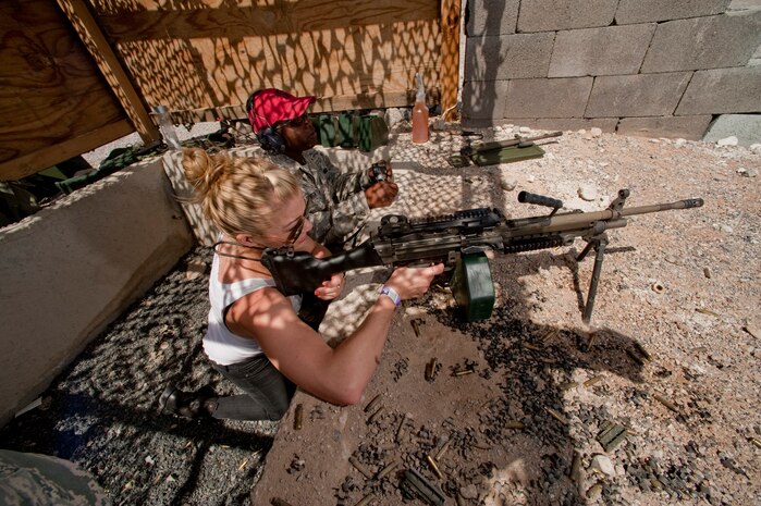 NEVADA TEST AND TRAINING RANGE --  Staff Sgt. Korey Hampton a combat arms instructor assigned to the 99th Ground Combat Training Squadron shows country music singer LeAnn Rimes how to fire a M240B machine gun at the 99th GCTS firing range April 17, 2010. The Academy of Country Music and the USO toured the 99th GCTS before performing a free concert at Nellis Air Force Base.  (U.S. Air Force photo by Tech. Sgt. Michael R. Holzworth)

