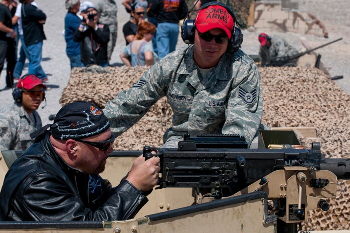 NEVADA TEST AND TRAINING RANGE --  Staff Sgt. Joshua Svendsen, a combat arms instructor assigned to the 99th Ground Combat Training Squadron  assists country music singer Eddie Montgomery to fire a 50 caliber machine gun from atop a HUMVEE at the 99th GCTS firing range April 17, 2010. The Academy of Country Music and the USO  toured  the 99th GCTS before performing a free concert at Nellis Air Force Base.  (U.S. Air Force photo by Tech. Sgt. Michael R. Holzworth)

