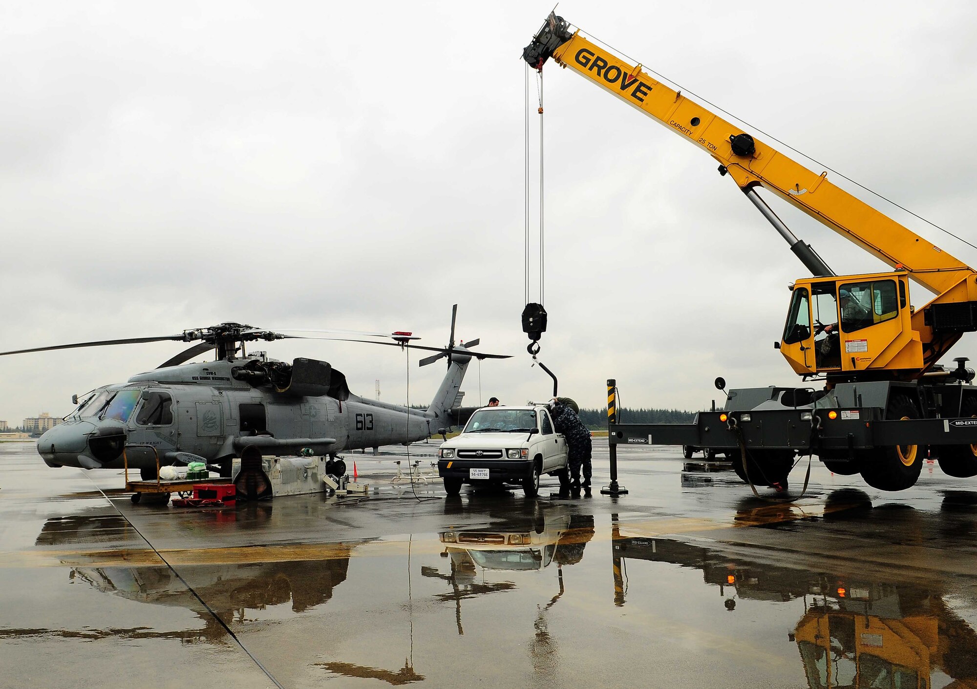 YOKOTA AIR BASE, Japan -- Airmen from Yokota help a Navy flight crew from Atsugi Naval Base, Japan repair an engine of their SH-60 Seahawk Helicopter here, April 15. The crew of the SH-60 was flying routine exercise maneuvers when they experienced problems which forced them to land at Yokota. (U.S. Air Force photo/Airman 1st Class Lynsie Lorenz)
