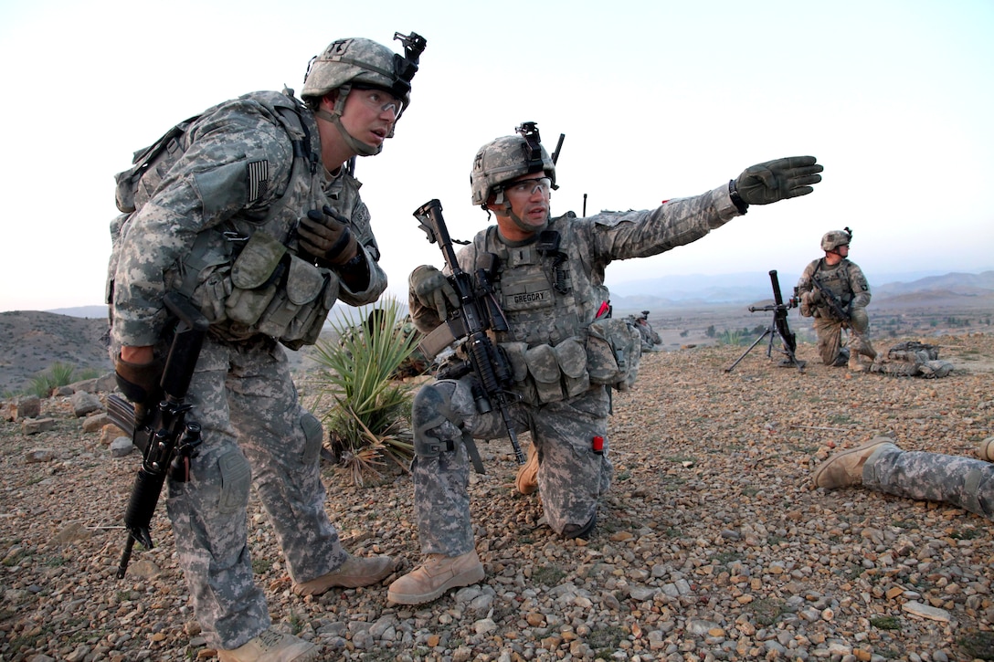 U.S. Army 1st Lt. Nicholas Gregory, kneeling, and Sgt. 1st Class Robert White discuss where to move next in Bak, Khowst province, Afghanistan, April 5, 2010. Gregory and White are assigned to the 101st Airborne Division's Company D, 3rd Battalion, 187th Infantry Regiment, 3rd Brigade Combat Team. The purpose of the mission was to clear safe houses and search suspected cache sites.
