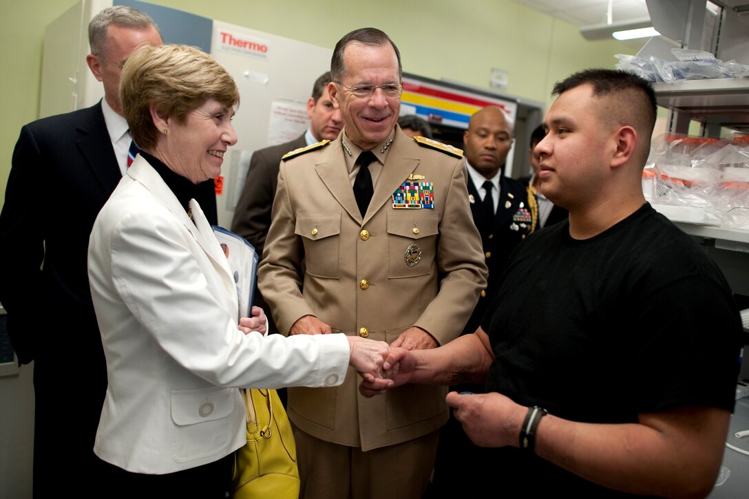 Navy Adm. Mike Mullen, chairman of the Joint Chiefs of Staff, and his wife, Deborah, greet U.S. Marine Cpl. Isaias Hernandez at the McGowan Institute for Regenerative Medicine in Pittsburgh, April 19, 2010. Hernandez, whose leg was severely wounded in Iraq, is a patient at the institute and has regrown most of his destroyed quadricep thanks to the gains in regenerative medicine.