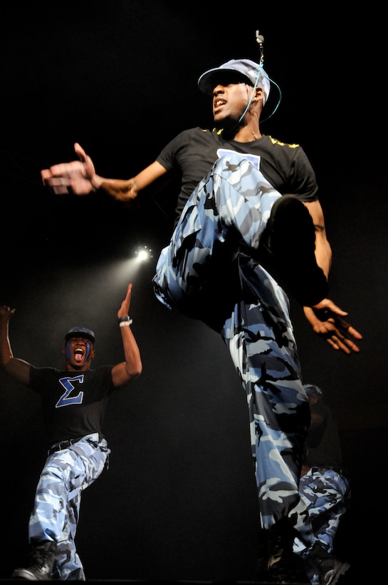 Adrienne Moorfield, the captain of the Sigma Phi Beta stomp-team, University of Oklahoma Chapter, gets the crowd pumped with thunderous stomp moves while his teammate cheers him on during the 2011 OU Stompdown Showcase, sponsored by the Marine Corps, April 30.  The men of Sigma Phi Beta went on to win the showcase and the "Marine Corps' Most Motivated Award," presented to the team who delivered the performance that most motivated the crowd.