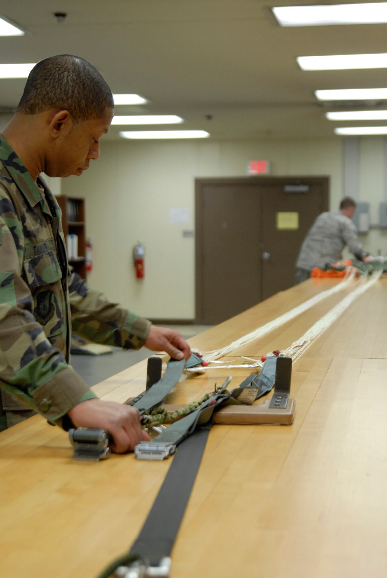 KUNSAN AIR BASE, Republic of Korea -- Staff Sgt. Cortney Tanner, Aircrew Flight Equipment Craftsman assigned to the 8th Operations Support Squadron, and Tech. Sgt. Jonathan Anlauf, Aircrew Flight Equipment NCOIC assigned to the 8th Operations Support Squadron, inspects the lines of a canopy pulled from its can, holder, here. This inspection ensures that the parachute is still serviceable and does not have any snags, tears, or rips. (U.S. Air Force photo/Staff Sgt. Darnell T. Cannady)