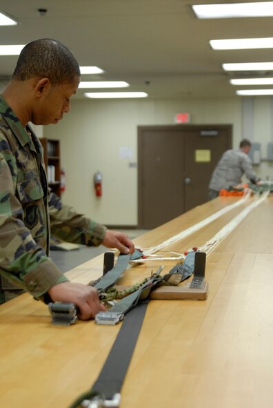 KUNSAN AIR BASE, Republic of Korea -- Staff Sgt. Cortney Tanner, Aircrew Flight Equipment Craftsman assigned to the 8th Operations Support Squadron, and Tech. Sgt. Jonathan Anlauf, Aircrew Flight Equipment NCOIC assigned to the 8th Operations Support Squadron, inspects the lines of a canopy pulled from its can, holder, here. This inspection ensures that the parachute is still serviceable and does not have any snags, tears, or rips. (U.S. Air Force photo/Staff Sgt. Darnell T. Cannady)