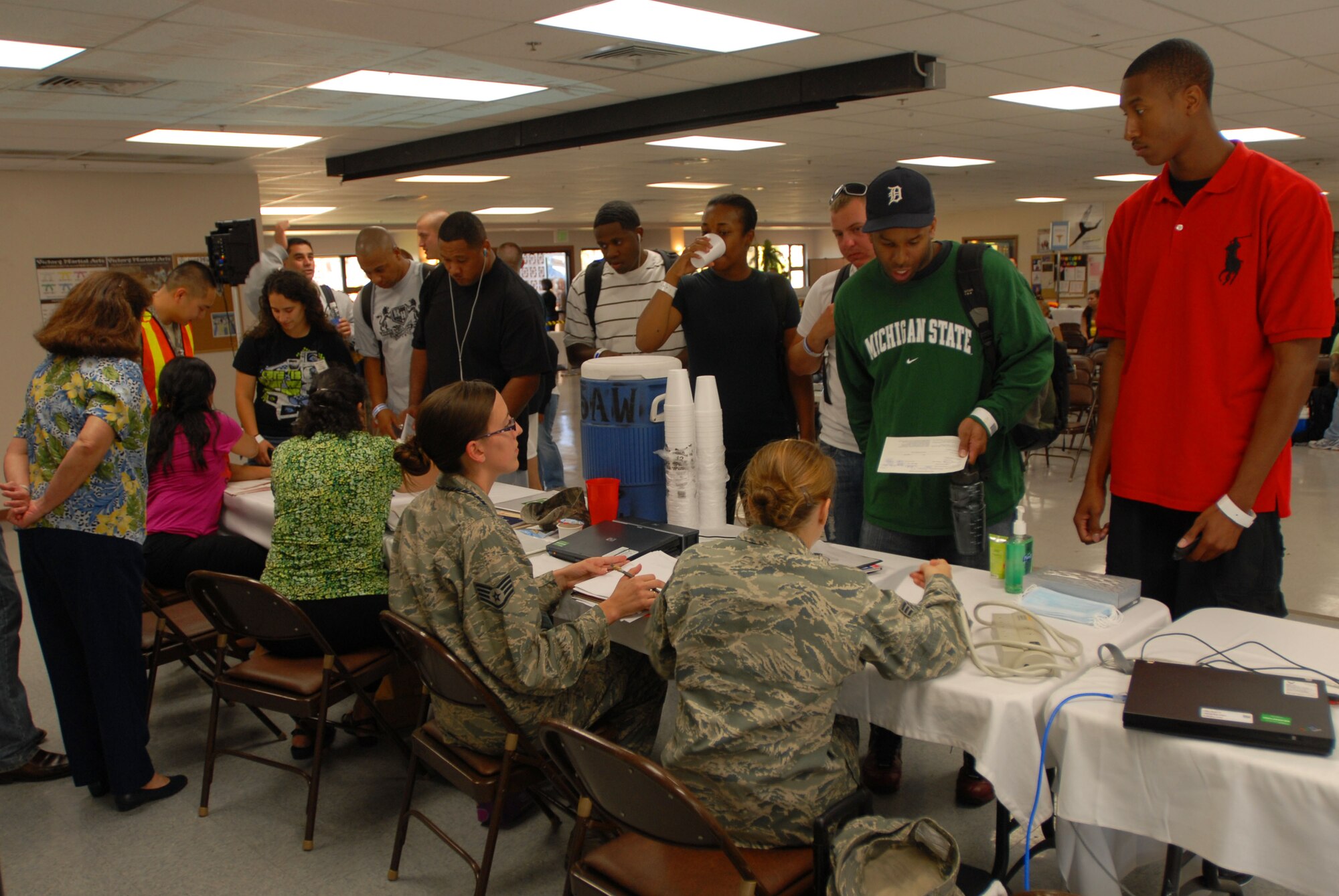Airmen and family members acting as evacuees are quickly briefed during the Non-combatant Evacuation Operation as part of the Operational Readiness Exercise here, April 20. The NEO tests the 15th Airlift Wing's capabilities to evacuate non-combatants. (U.S. Air Force photo/Senior Airman Gustavo Gonzalez)