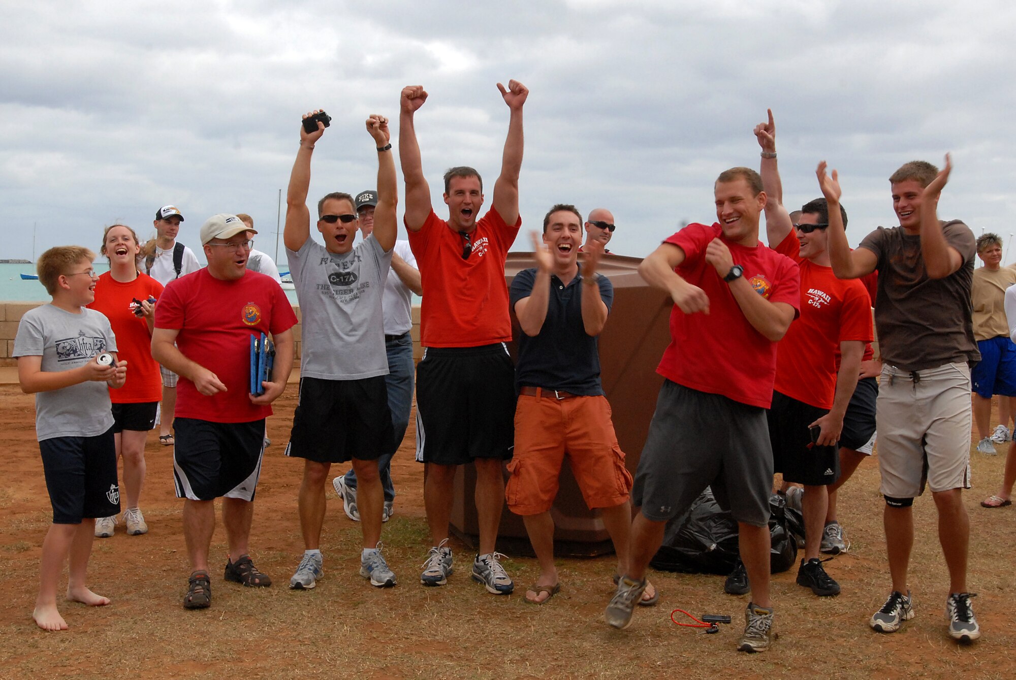 JOINT BASE PEARL HARBOR HICKAM, Hawaii -- Members of the 535th Airlift Squadron celebrates at the announcement of their victory during Hickam's annual Sports Day at Hickam Harbor April 16. The 535th AS placed first in the inner tube relay race and the fitness challenge. They placed second in the kayak race and third in volleyball. The entire day of activities also included horseshoe toss and the tug-o-war. At the end of the day, the Chiefs took down the Eagles in a volleyball game. (U.S. Air Force photo by Staff Sgt. Mike Meares)