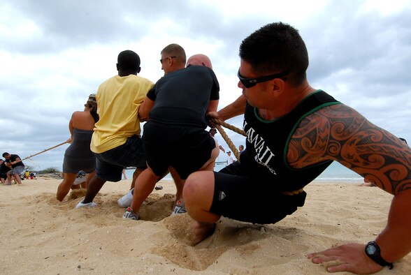 JOINT BASE PEARL HARBOR HICKAM, Hawaii -- Senior Airman Nick Rapoza, 15th Security Forces Squadron, pulls with the rest of his defenders team against the 324th Intelligence Squadron during the tug-o-war competition at Hickam's annual Sports Day at Hickam Harbor April 16. After losing to the 15th Operations Support Squadron, the defenders beat the 15th Civil Engineer Squadron for third place. (U.S. Air Force photo by Staff Sgt. Mike Meares)