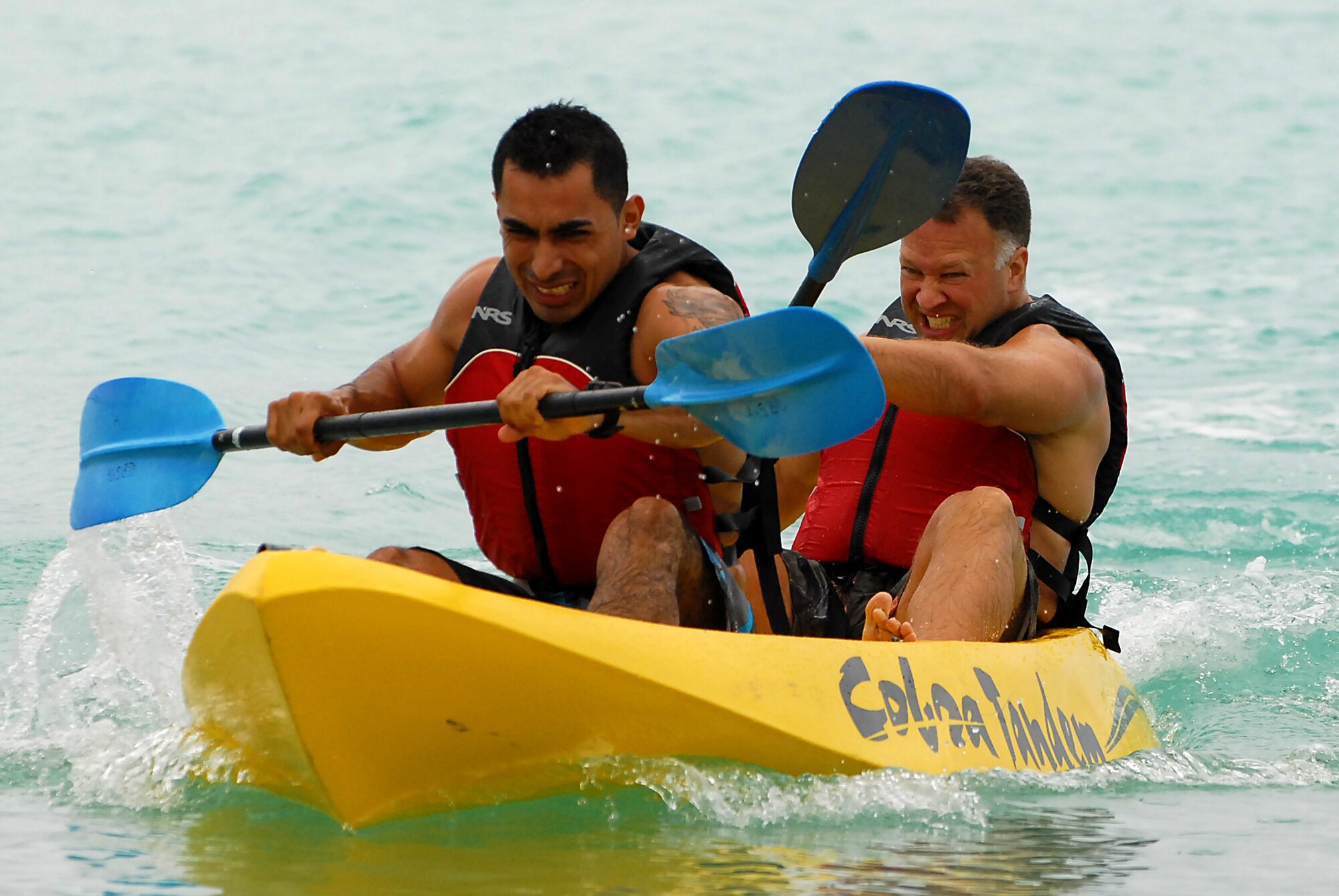JOINT BASE PEARL HARBOR HICKAM, Hawaii ? Senior Airman Raul Castillo and Lt. Col. Scott Weber, 15th Operations Support Squadron, vigorously paddle to finish the kayak race during Hickam?s annual Sports Day at Hickam Harbor April 16. The 735th Aircraft Maintenance Squadron beat the 535th Airlift Squadron by two tenths of a second to claim the first spot. The 15th Operations Support Squadron turned a time of :59 to take third place during the three team playoff. The Airman Castillo and Colonel Weber recorded the best time overall of :55 on their first run, but took third in the finals.