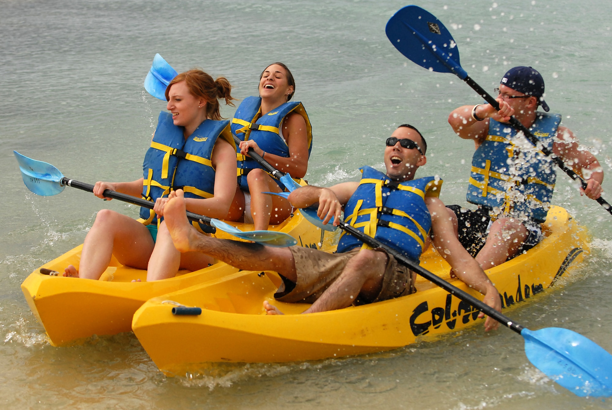 JOINT BASE PEARL HARBOR HICKAM, Hawaii ? Airmen 1st Class Charles Fletcher and Carson Porter, 15th Security Forces Squadron, celebrate after edging Airman 1st Class Sarah Terry and Julia Castillo, 15th Airlift Wing legal office, by the tip of the kayak during Hickam?s annual Sports Day at Hickam Harbor April 16. The 735th Aircraft Maintenance Squadron beat the 535th Airlift Squadron by two tenths of a second to claim the first spot during the finals. The 15th Operations Support Squadron turned a time of :59 to take third place during the three team playoff. The 15th OSS recorded the best time overall of :55 on their first run. (U.S. Air Force photo by Staff Sgt. Mike Meares)