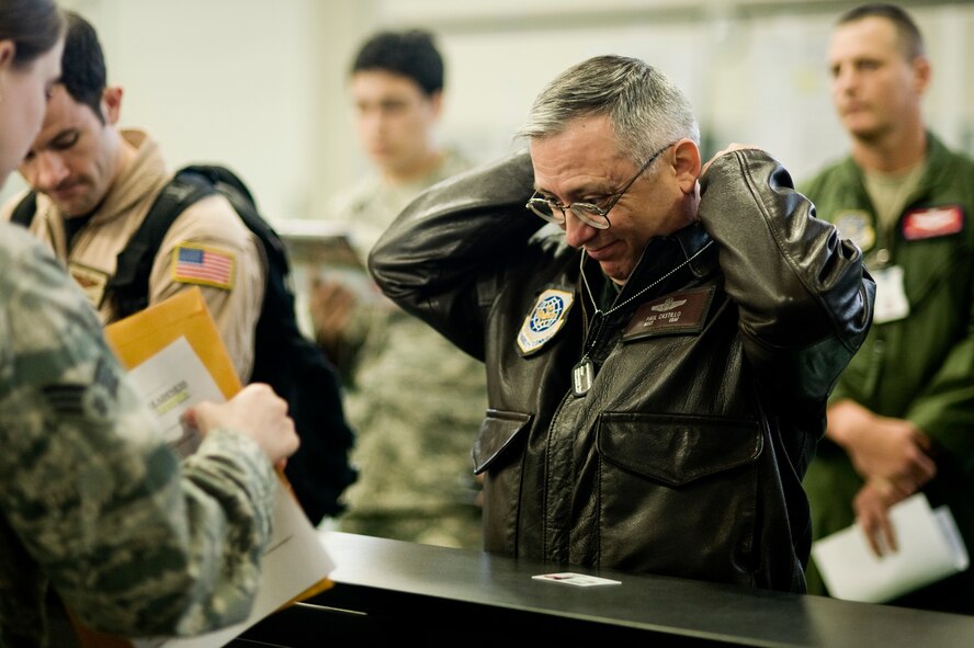 Master Sgt. Paul Castillo, 8th Airlift Squadron, dons his dog tags while processing through a deployment line here April 20. Sergeant Castillo is one of more than 100 McChord Field Airmen deploying with the 8th AS to the Middle East.  The mission of the 8th Airlift Squadron is to train and equip C-17 Globemaster III aircrews for global air-land and airdrop operations.  (U.S. Air Force Photo by Abner Guzman)
