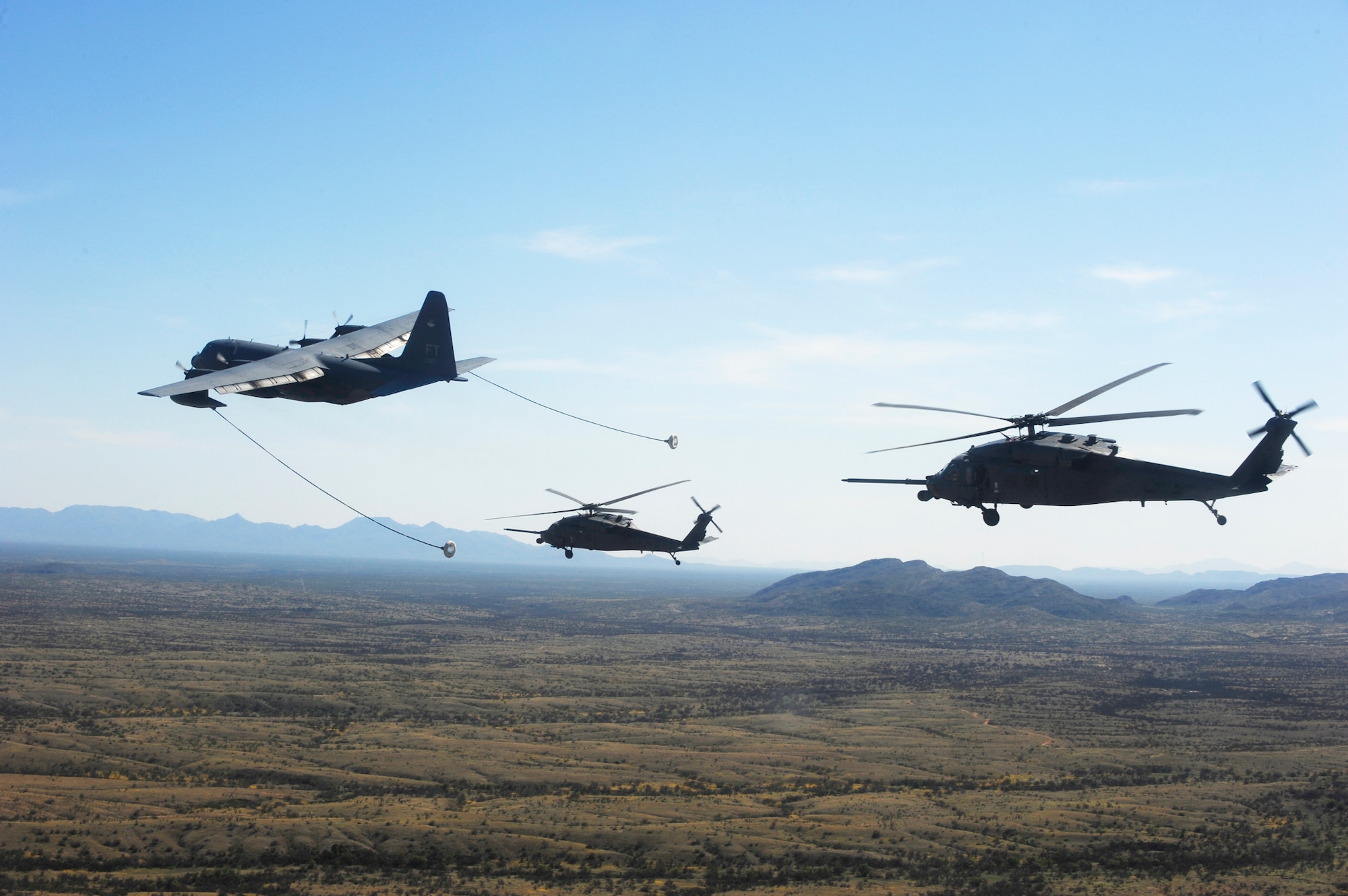An HC-130P/N King refuels two HH-60 Pave Hawks April 15, 2010, over the desert surrounding Davis-Monthan Air Force Base, Ariz., during Angel Thunder 2010. The HC-130 is with the 71st Rescue Squadron at Moody AFB, Ga.  Angel Thunder 2010, an Air Combat Command-sponsored exercise, will be the largest personnel recovery and combat search and rescue exercise to date, combining Department of Defense and non-DOD assets.  (U.S. Air Force photo/Staff Sgt. Joshua L. DeMotts) 