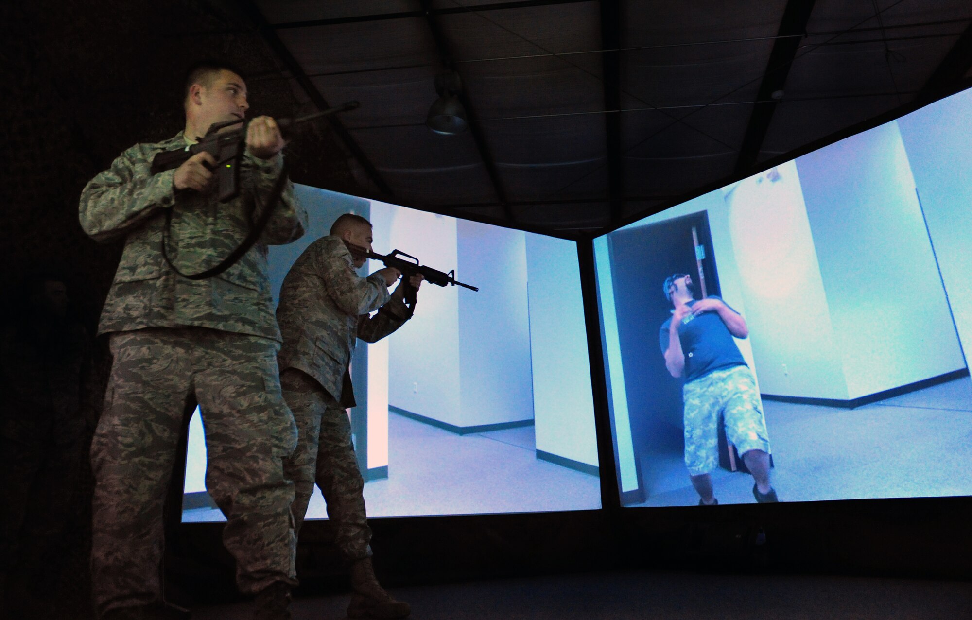 Capt. Kevin Snow and Capt. Frank Rovello exchange gunfire with "insurgents" April 15, 2010, during a battlefield training scenario in the 621st Contingency Response Wing's new virtual firearms training simulator at Joint Base McGuire-Dix-Lakehurst, N.J.  Captain Snow is the 818th Global Mobility Squadron Assistant Operations Officer and Captain Rovello is the 21st Air Mobility Operations Squadron Readiness Flight commander.  (U.S. Air Force photo/Tech. Sgt Parker Gyokeres)