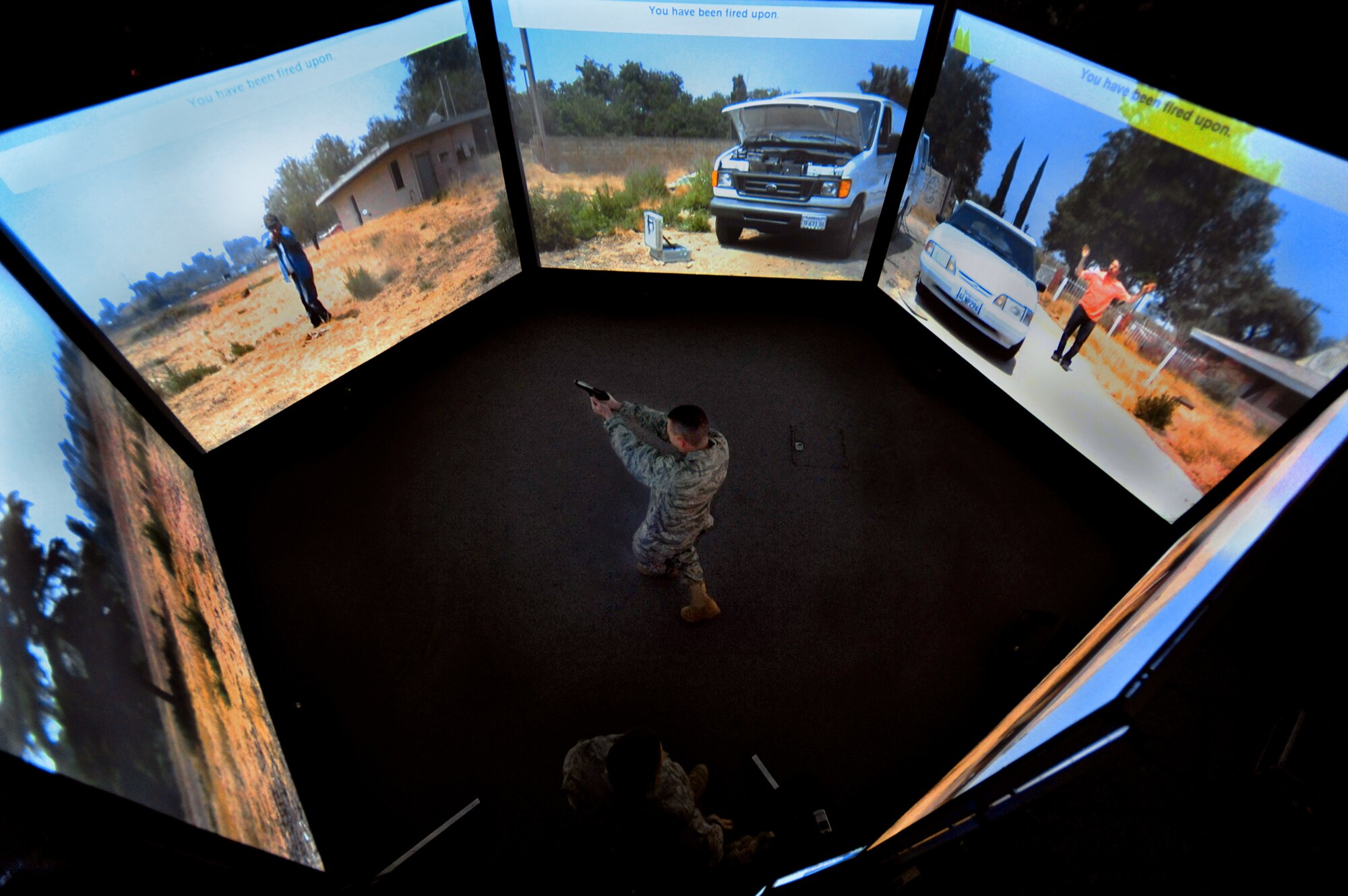 Capt. Kevin Snow exchanges gunfire with an "attacker" April 15, 2010, during a training scenario in the 621st Contingency Response Wing's new virtual firearms training simulator at Joint Base McGuire-Dix-Lakehurst, N.J..  The 300-degree field-of-view simulator is used to train Airmen to anticipate and react appropriately to threats from any direction.  Captain Snow is the 818th Global Mobility Squadron Assistant Operations Officer. (U.S. Air Force photo/Tech. Sgt Parker Gyokeres)