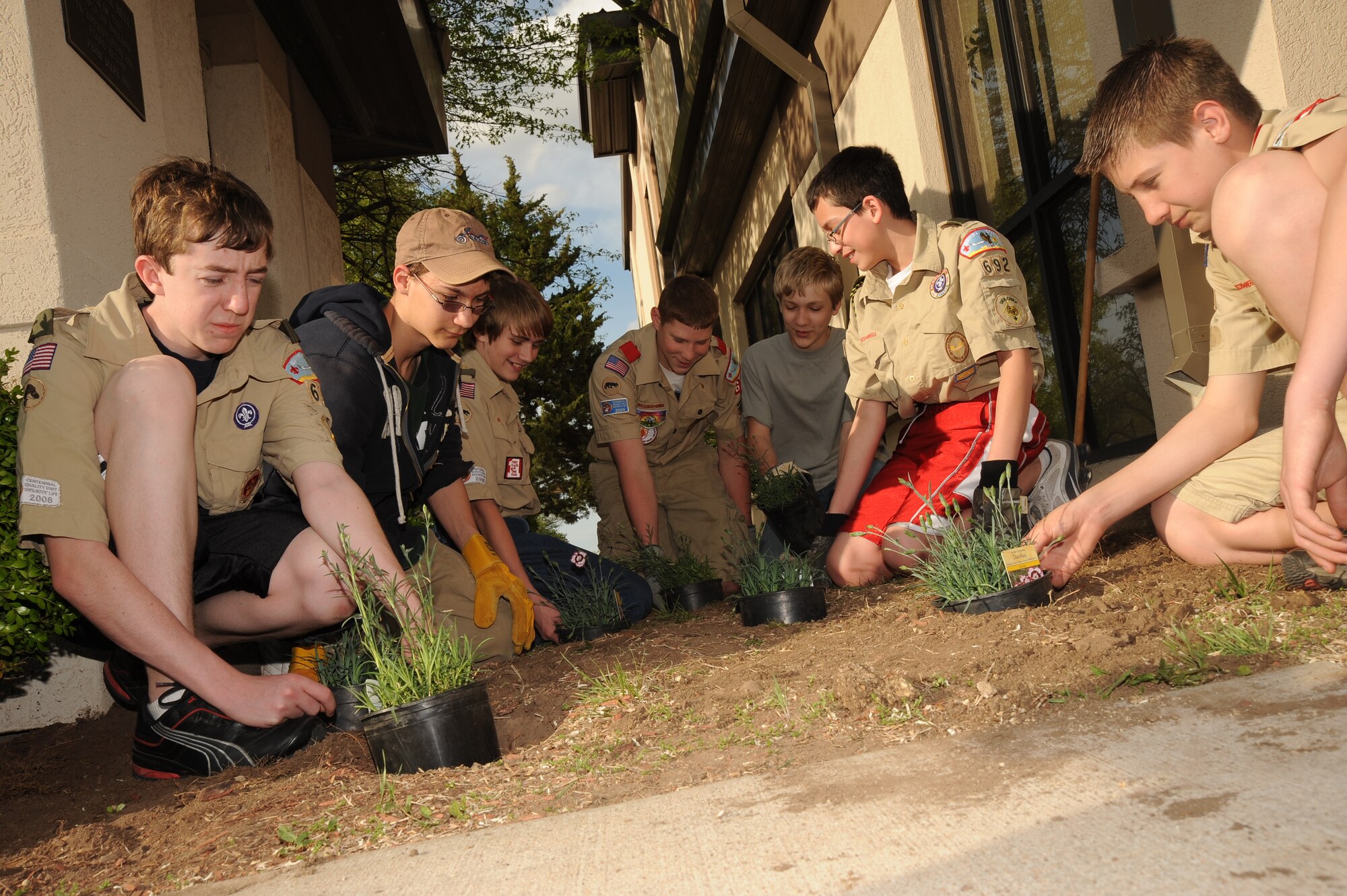 Derby Boy Scouts Troop 692 members plant flowers at the base chapel April 15, 2010, McConnell Air Force Base, Kan. Troop 692 re-landscaped the base chapel as a community project to earn a scout merit badge, while also saving the chapel more than $800 in landscaping costs. The base chapel supports the wing mission and combatant commanders by providing spiritual care, advice to leadership and free exercise of religion to all assigned personnel and their families. (U.S. Air Force photo/Tech. Sgt. Chyrece Campbell)