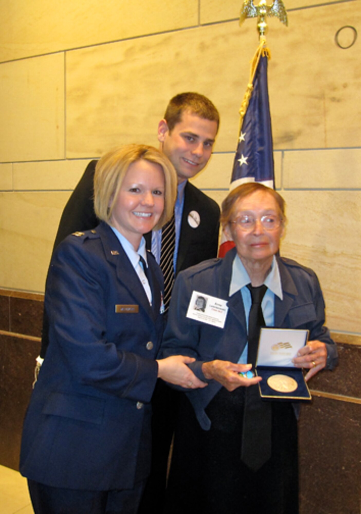 Capt. Marci Matthews, a C-5 pilot assigned to the 709th Airlift Squadron, presents the Congressional Gold Medal to Anne Lesnikowski, one of the Women Air Force Service Pilots from the 1940s. Of the 300 surviving WASPs, about 200 attended the medal presentation in the nation's Capitol March 10. Captain Matthews is one of five female aviators from the 512th Operations Group, who volunteered to serve as a personal WASP escort for the two-day event, honoring all WASPs March 9-10. Also pictured is Ms. Lesnikowski's nephew.                                