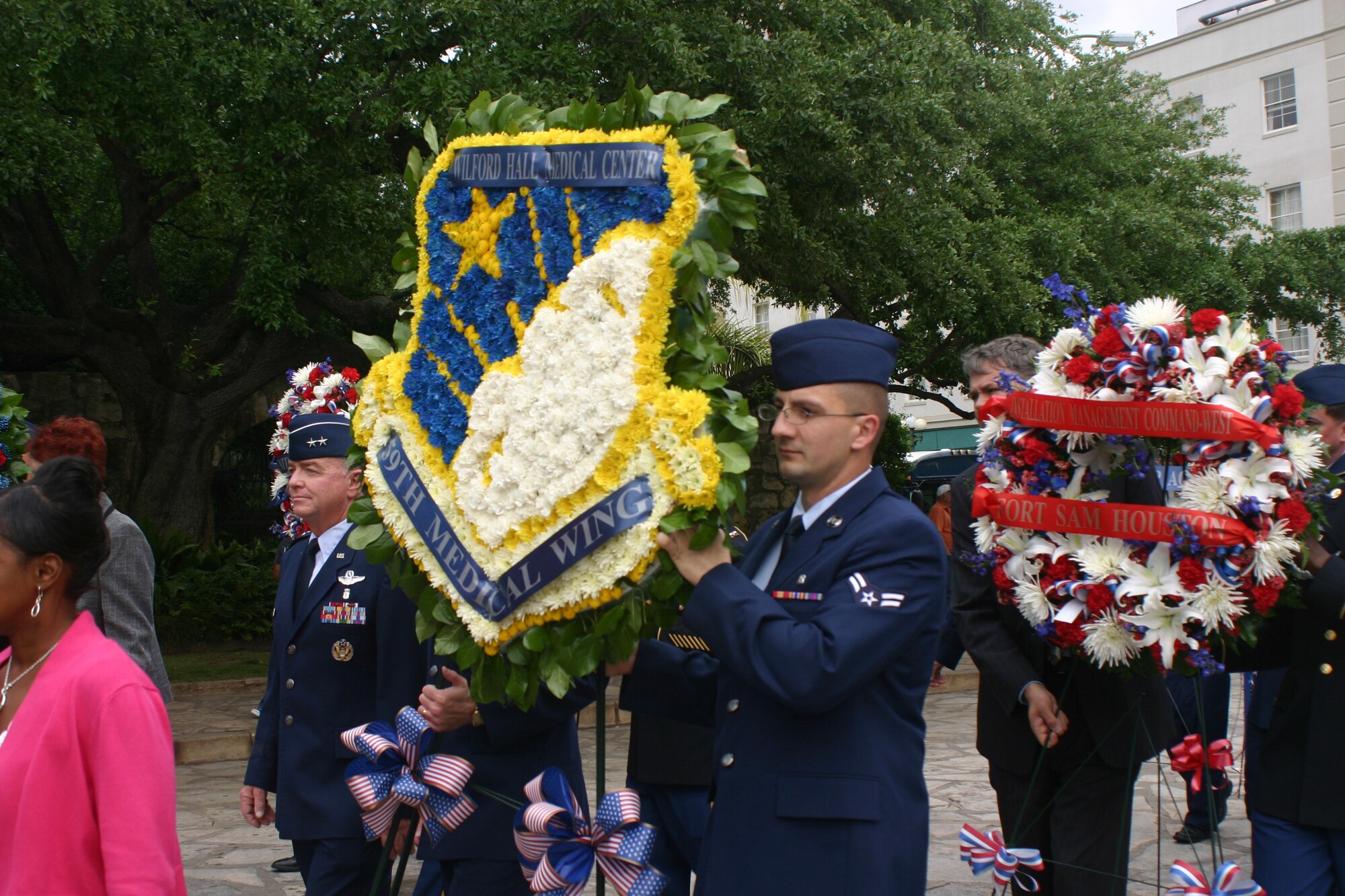 Maj. Gen. Tom Travis, 59th Medical Wing commander, (left) and Senior Airman Romulus Kocsis, 59th Dental Support Squadron, (right) march in the Pilgrimage to the Alamo carrying the 59th Medical Wing wreath on April 19. Not pictured is Chief Master Sgt. Richard Robinson, 59th MDW command chief.  The Pilgrimage, a memorial tribute to the Alamo heroes, is one of many events the Medical Wing supports during Fiesta San Antonio. (U.S. Air Force photo/ Linda Frost)
