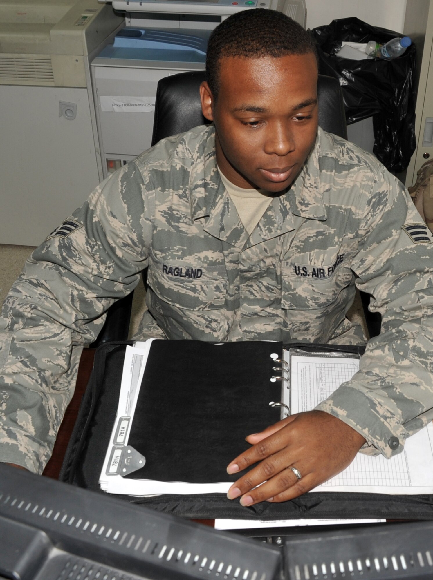 Senior Airman Alex Ragland, a communications and navigations journeyman with the 380th Expeditionary Aircraft Maintenance Squadron, works at his desk in the squadron where he works as an aircraft maintenance debriefer on the KC-10 Extender airframe.  Airman Ragland is deployed from the 305th Aircraft Maintenance Squadron at Joint Base McGuire-Dix-Lakehurst, N.J., and his hometown is Gadsden, Ala. (U.S. Air Force Photo/Master Sgt. Scott T. Sturkol/Released)