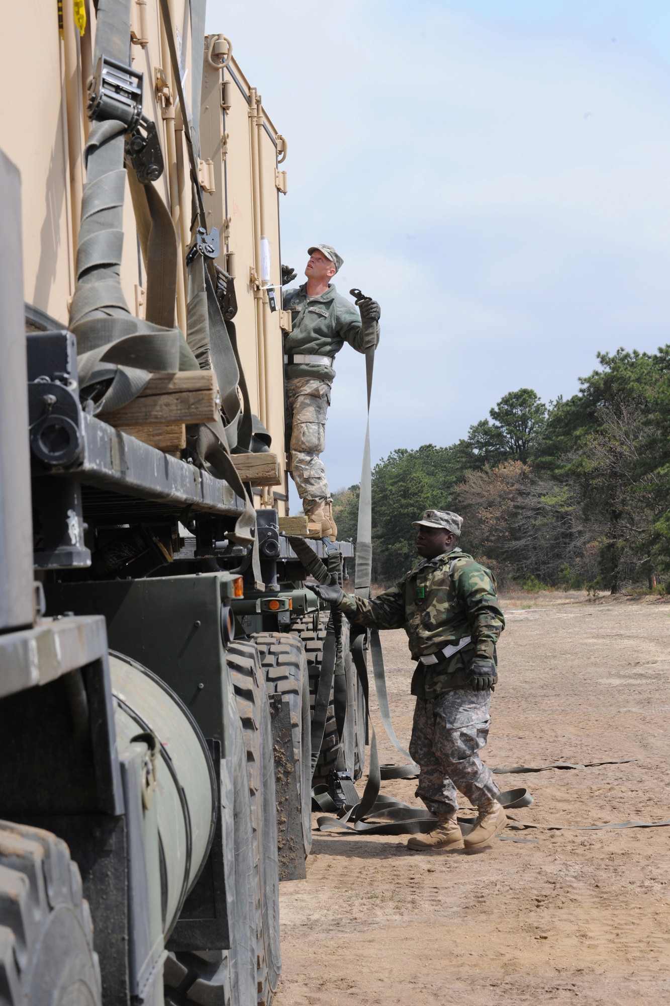 Pfc. Jason Farner, truck driver, and Staff Sgt. Delawrence Jones, yard manager, fasten down ISU 90 containers on a load-handling system cargo truck during Exercise Eagle Flag April 16 at Joint Base McGuire-Dix-Lakehurst. Eagle Flag provides U.S. forces with an environment to exercise the knowledge and skills required for any type of forward operation, in any environment, regardless of mission or aircraft type. (U.S. Air Force Photo/Staff Sgt. Nathan G. Bevier)