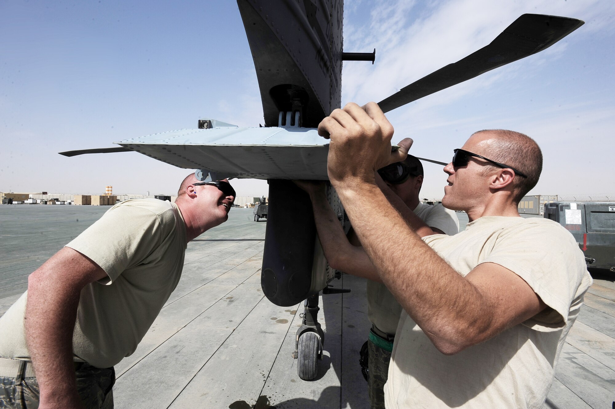 Left to right, Staff Sgts. Greg Enberlin, Ryan Click and Senior Airman Robert Fabela, HH-60G Pave Hawk crew chiefs assigned to the 451st Expeditionary Aircraft Maintenance Squadron helicopter maintenance unit,  install a stabalator on a back-up HH-60G helicopter April, 16, 2010, at Camp Bastion, Afghanistan. The maintenance Airmen, who have witnessed as many as 26 sorties here in one day, spend an average of 168 man-hours a week to ensure rescue aircrews are ready to fly when called. (U.S. Air Force photo/Staff Sgt. Manuel J. Martinez/released)