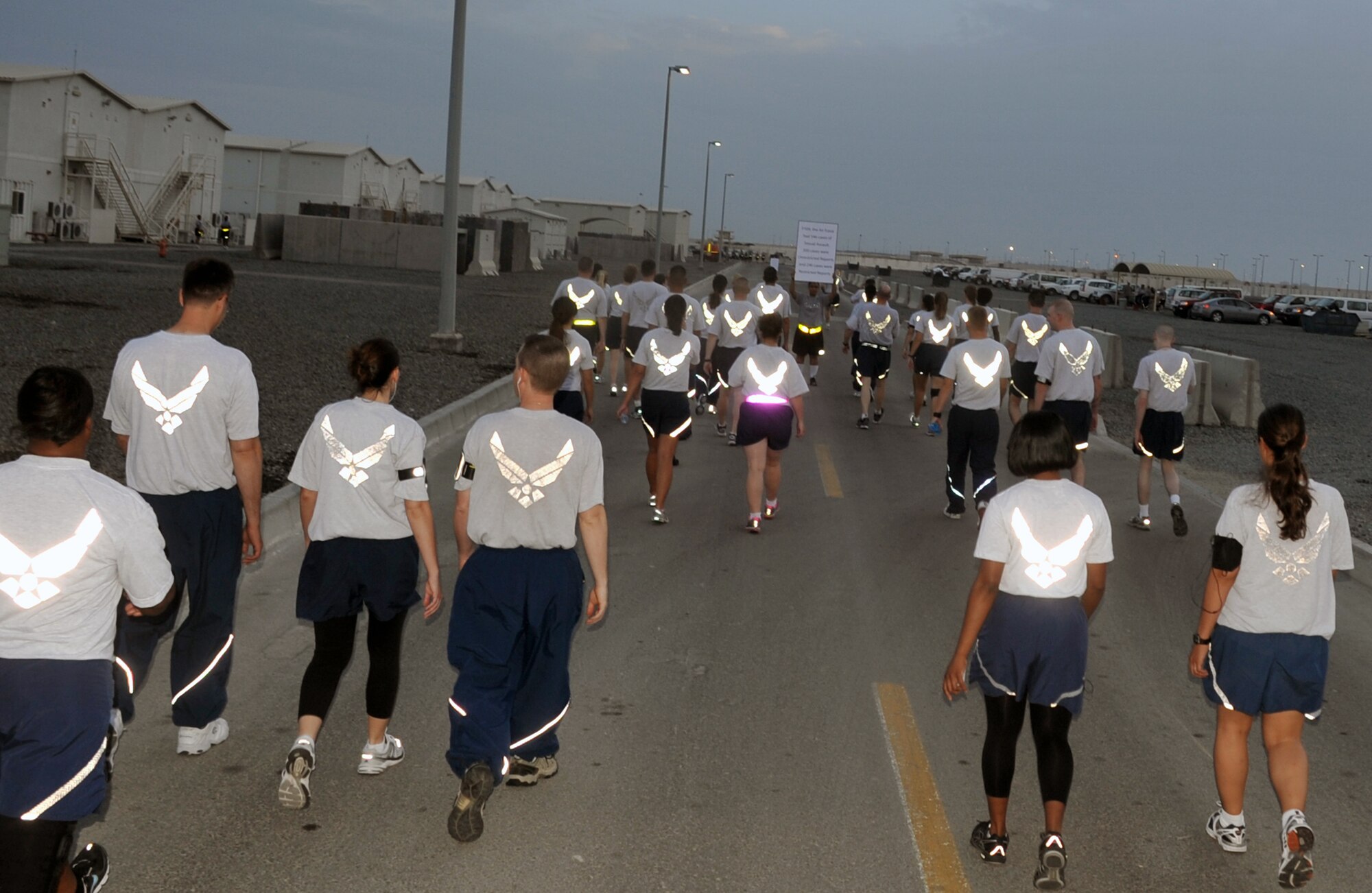 Airmen from the 380th Air Expeditionary Wing participate in the "Walk A Mile In Their Shoes" event by the 380th Air Expeditionary Wing at a non-disclosed base in Southwest Asia on April, 19, 2010, in observance of Sexual Assault Awareness Month. Throughout a one-mile walk, signs with information on sexual assault were placed while walk participants read them and walked in silence. The event was organized by Capt. Richard Laca -- the 380th AEW sexual assault response coordinator. (U.S. Air Force Photo/Master Sgt. Scott T. Sturkol/Released)