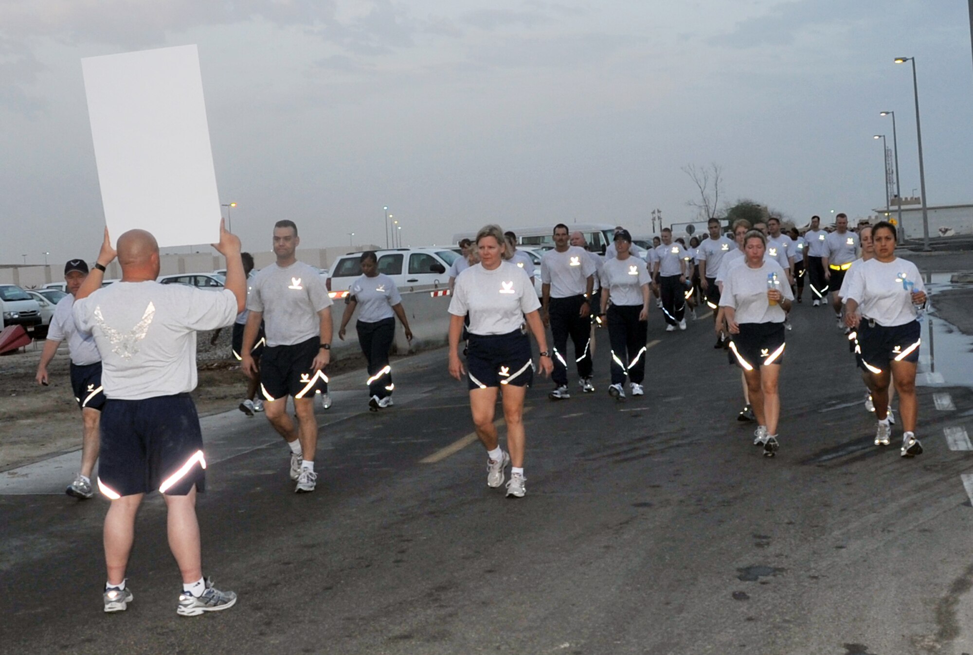 Airmen from the 380th Air Expeditionary Wing participate in the "Walk A Mile In Their Shoes" event by the 380th Air Expeditionary Wing at a non-disclosed base in Southwest Asia on April, 19, 2010, in observance of Sexual Assault Awareness Month. Throughout a one-mile walk, signs with information on sexual assault were placed while walk participants read them and walked in silence. The event was organized by Capt. Richard Laca -- the 380th AEW sexual assault response coordinator. (U.S. Air Force Photo/Master Sgt. Scott T. Sturkol/Released)