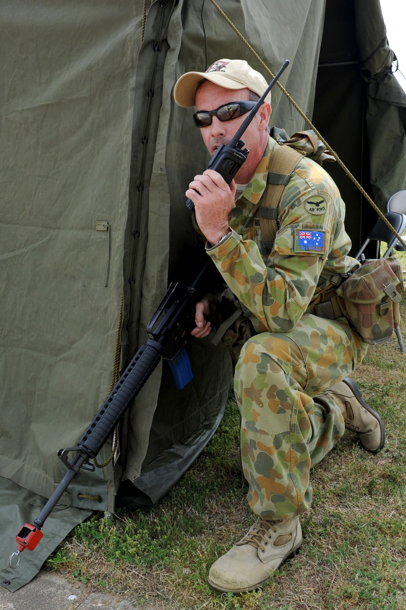 Warrant Officer Mick Lennon, Royal Australian Air Force 37 Squadron, calls to check the status of other companies during a simulated attack on the Little Rock Air Force Base flightline during an exercise April 19 near Bldg. 160. The U.S. Air Force conducts joint training with nations to enhance our abilities to work as a cohesive unit in joint deployed environments. (U.S. Air Force photo by Senior Airman Ethan Morgan)