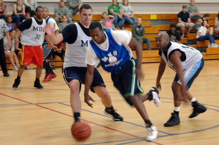 Travis Taylor, center, tries to get past Justin Steidler, left, and Adam Garrett, right, during the base intramural basketball championship game held at the Fitness and Sports Center April 16, 2010, at Joint Base Charleston, S.C. The 628th Medical Group pushed hard in the second half to overcome a 16-point lead held by the 437th Maintenance Squadron. Taylor is assigned to the 437 MXS; Steidler and Garrett are assigned to the 628 MDG. (U.S. Air Force photo/Staff Sgt. Marie Brown)