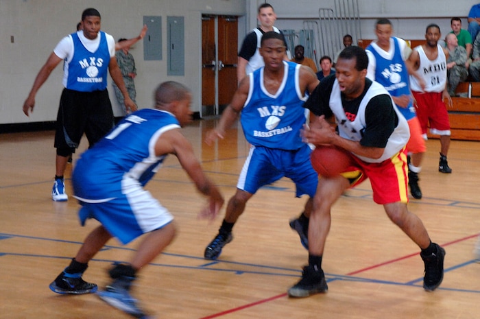 Cervante Harris tries to hold on to the ball as members of the 437th Maintenance Squadron prepare for a steal during the base intramural basketball championship game held at the Fitness and Sports Center April 16, 2010, at Joint Base Charleston, S.C. After a series of fouls in the second half which cost the 437 MXS their lead, the 628th Medical Group won 38-32. Harris is assigned to the 628 MDG. (U.S. Air Force photo/Staff Sgt. Marie Brown)