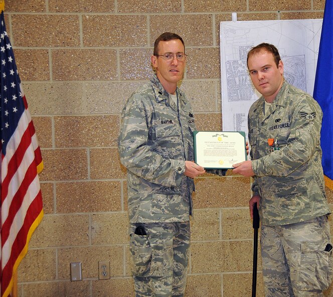 OFFUTT AIR FORCE BASE, Neb. --- Lt. Col. Brian Barthel, 55th Security Forces Squadron commander, presents Senior Airman Victor Wise, 55th SFS, with one of two Army Commendation Medals at a ceremony here April 14. Airman Wise also recieved the Air Force Combat Action Medal during the ceremony for his selfless actions to save lives after a convoy he was traveling in was hit by an improvised explosive device while he was deployed to Iraq. The AFCAM is awarded to Airmen who have been active participants in combat, while being under direct and hostile fire as they physically engaged hostile forces with direct and lethal fire in connection with military operations. U.S. Air Force photo by Kendra Williams 
