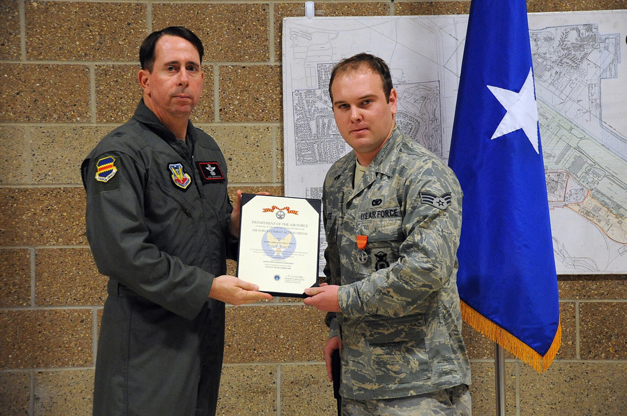 OFFUTT AIR FORCE BASE, Neb. -- Brig. Gen. John N.T. Shanahan, 55th Wing commander, presents Senior Airman Victor Wise, 55th Security Forces Squadron, with the Air Force Combat Action Medal during a ceremony here April 14. Airman Wise received the medal, as well as two Army Commendation Medals during the ceremony, for his selfless actions to save lives after a convoy he was traveling in was hit by an improvised explosive device while he was deployed to Iraq. The AFCAM is awarded to Airmen who have been active participants in combat, while being under direct and hostile fire as they physically engaged hostile forces with direct and lethal fire in connection with military operations. U.S. Air Force photo by Kendra Williams