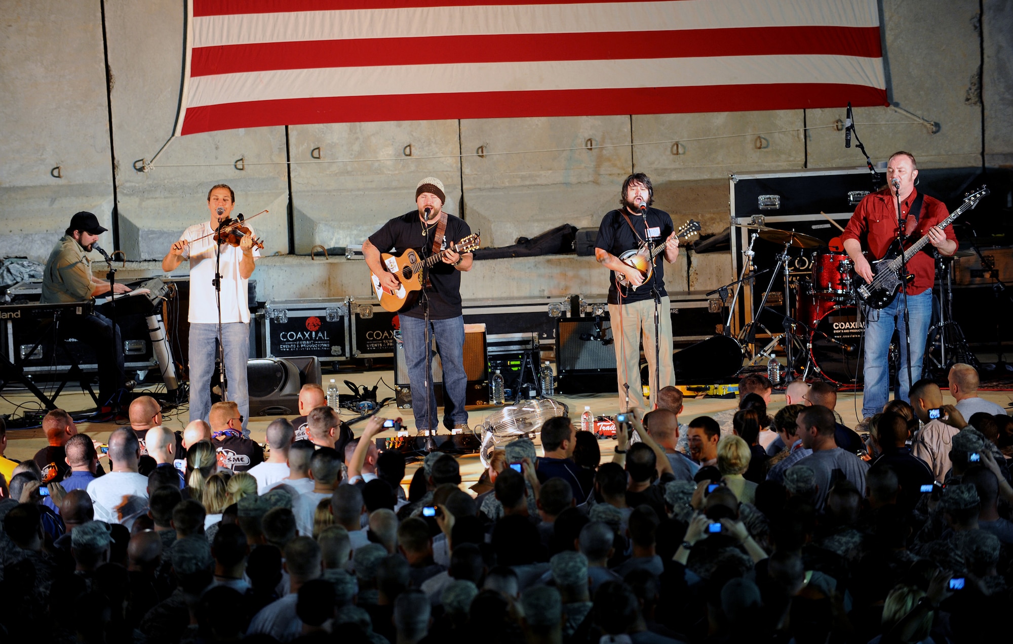 Members of the Zac Brown Band perform for a crowd of deployed personnel at Holt Stadium at Joint Base Balad, Iraq, April 18, 2010. The Grammy-nominated band is touring various bases throughout Southwest Asia to perform for the troops rather than attend this year's Academy of Country Music Awards for which they were nominated for several awards. (U.S. Air Force photo by Master Sgt. Linda C. Miller/Released)