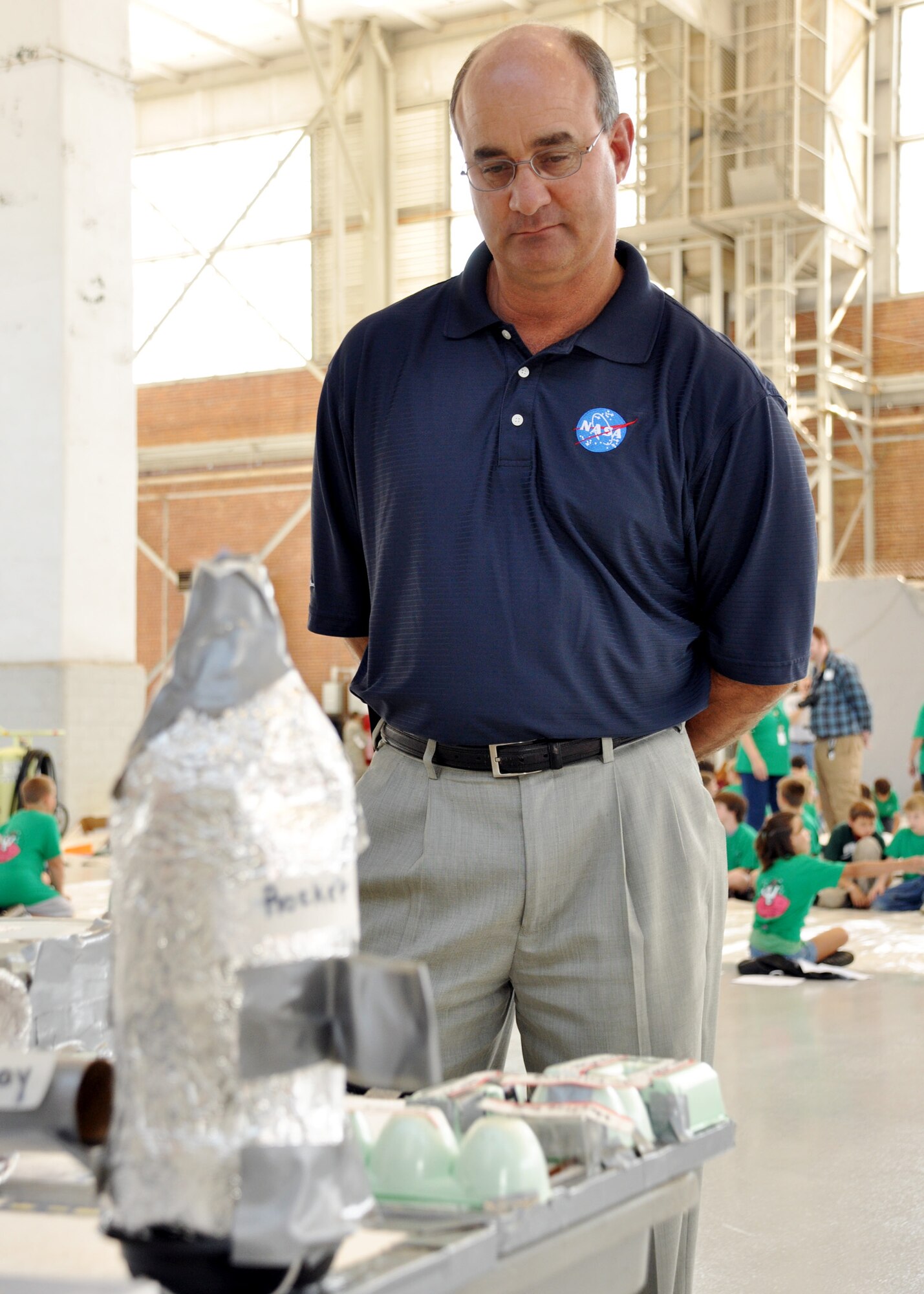 Billy Stover,  NASA Space Transportation Planning technical manager, judges the problem-solving projects at the Marsville event at Eglin Air Force Base April 16.  More than 120 students from Wright, Longwood and Valparaiso elementary schools gathered on Eglin for a single mission: build a life-sustaining pod on Mars.   The 15th annual Marsville event is a collaborative effort between Eglin and the surrounding community's elementary school fifth-grade students, and faculty members. One of its top goals is to encourage students to pursue careers in science and engineering.  (U.S. Air Force photo/Staff Sgt. Stacia Zachary.)