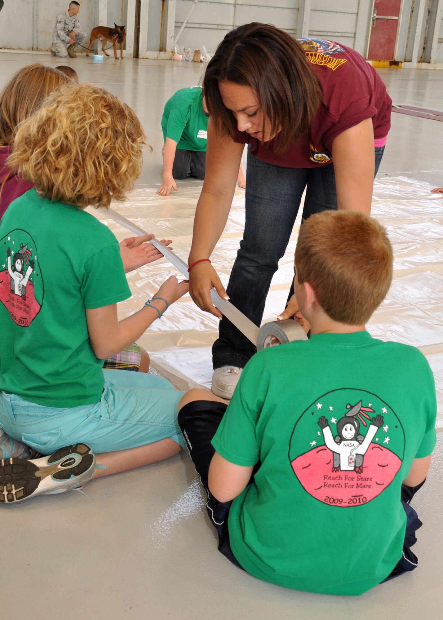 A Niceville High School Junior Reserve Officer Training Corps student helps kids from Valparaiso Elementary School build the Mars pod living units at Eglin Air Force Base April 16.  More than 120 students from Wright, Longwood and Valparaiso elementary schools gathered on Eglin for a single mission: build a life-sustaining pod on Mars.   The 15th annual Marsville event is a collaborative effort between Eglin and the surrounding community's elementary school fifth-grade students, and faculty members. One of its top goals is to encourage students to pursue careers in science and engineering.  (U.S. Air Force photo/Staff Sgt. Stacia Zachary.)