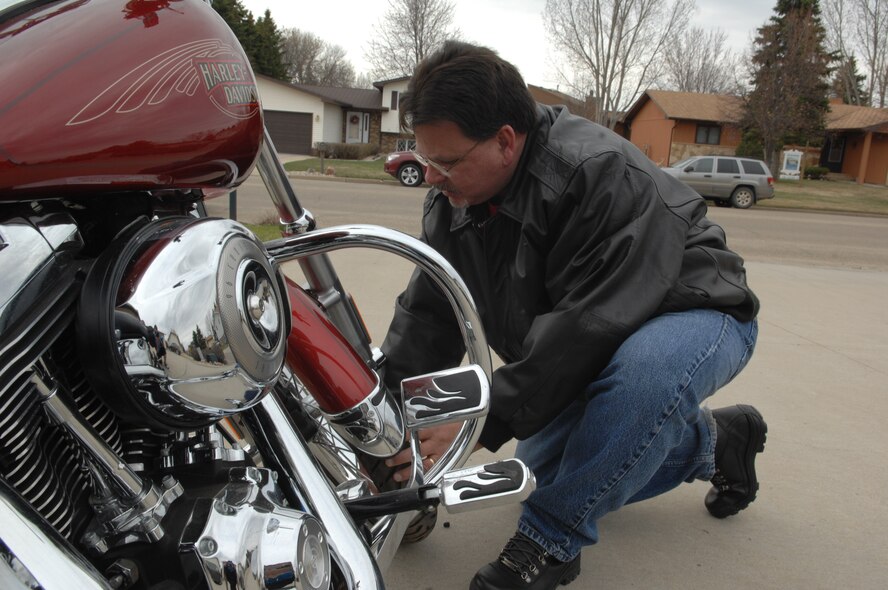 MINOT, N.D. -- Rod Krause, 5th Bomb Wing ground safety manger, checks his tire pressure prior to taking a ride into town on his motorcycle here April 18. Minot Airmen should perform routine checks on their motorcycles to ensure safe operations and an enjoyable ride. (U.S. Air Force photo by Senior Airman Michael J. Veloz)